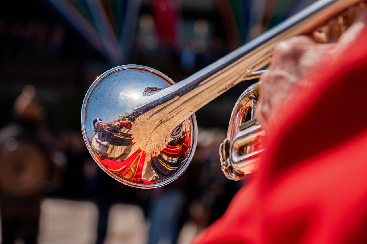 services-02 Vivid close-up of a shiny trumpet with reflections during an outdoor performance.